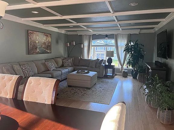 Open Concept Dining to Living Room with coffered ceilings and large picture window to allow in plenty of natural light.