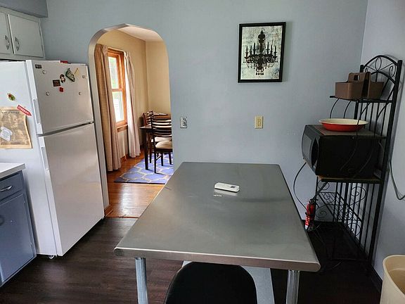 Kitchen features stainless steel prep island and two bar stools.