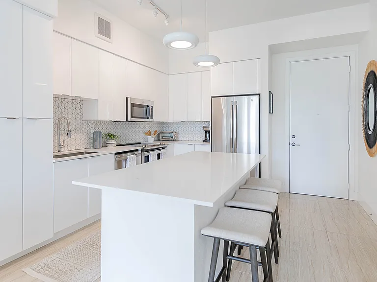 Gourmet kitchens with quartz countertops and backsplashes, modern light fixtures and stainless-steel appliances