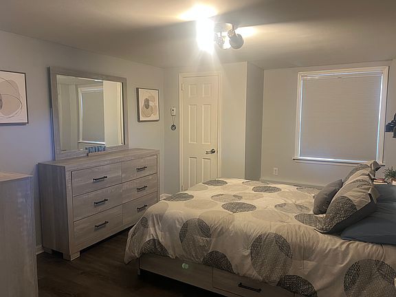 Spacious bedroom with closet and vinyl flooring.