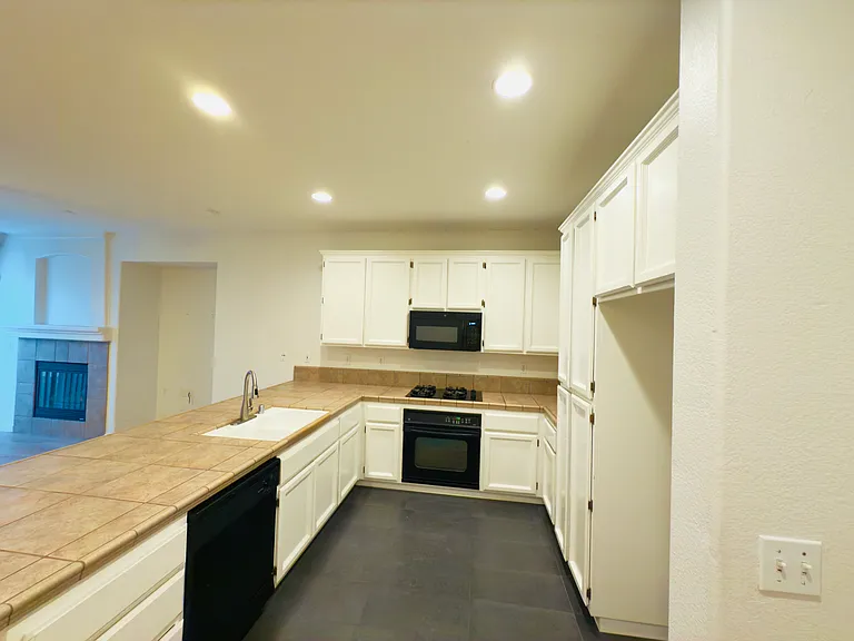 The kitchen boasts a sleek U-shaped modern design, high ceilings, and the perfect layout for cooking and entertaining!