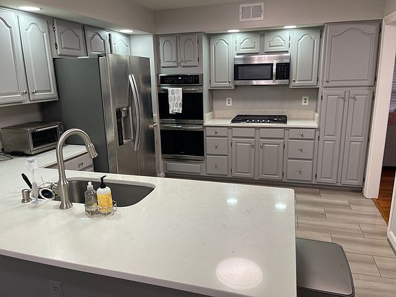 Kitchen with double oven, and stainless steel appliances. Stove is new.