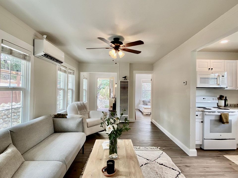 Living room with view of kitchen, front door, and bedroom 2