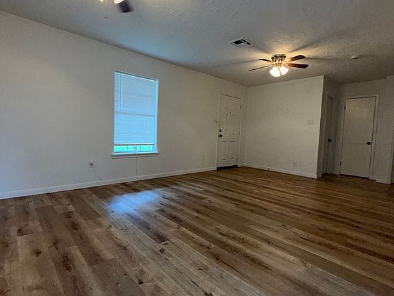 Sala amplia de concepto abierto con piso estilo madera y ventiladores de techo, vista desde el comedor.//

Spacious open-concept living room with modern wood-style flooring and ceiling fans, view from dining area.