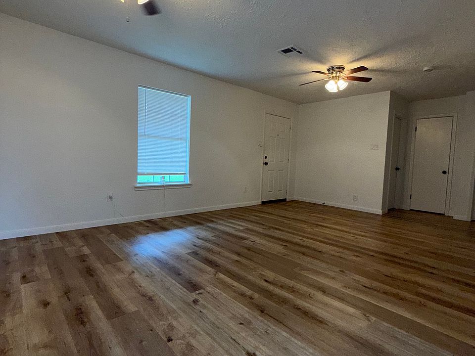 Sala amplia de concepto abierto con piso estilo madera y ventiladores de techo, vista desde el comedor.//

Spacious open-concept living room with modern wood-style flooring and ceiling fans, view from dining area.