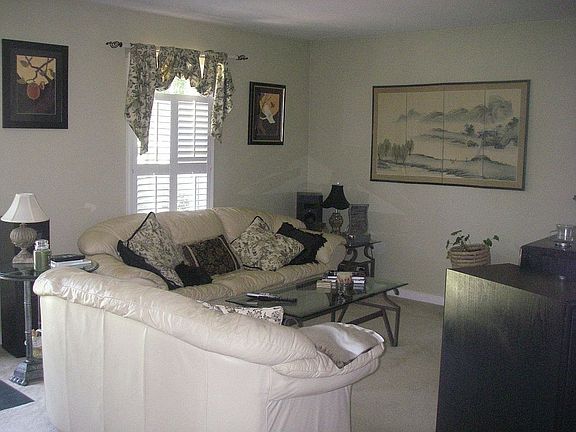 Open, airy living room with gas FP, plantation shutters