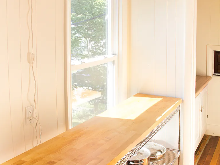 Large butcher block work surface with storage underneath. Pantry in the background.