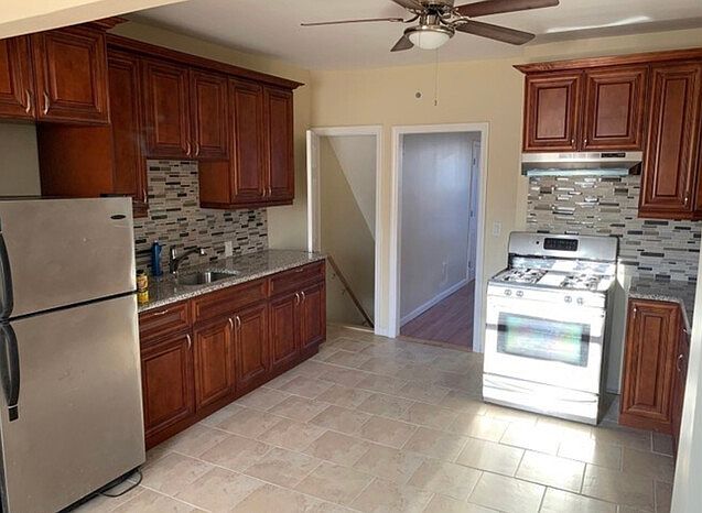 Kitchen w. Wooden cabinets/ Stove/Refrigerator/ Ceiling Fan