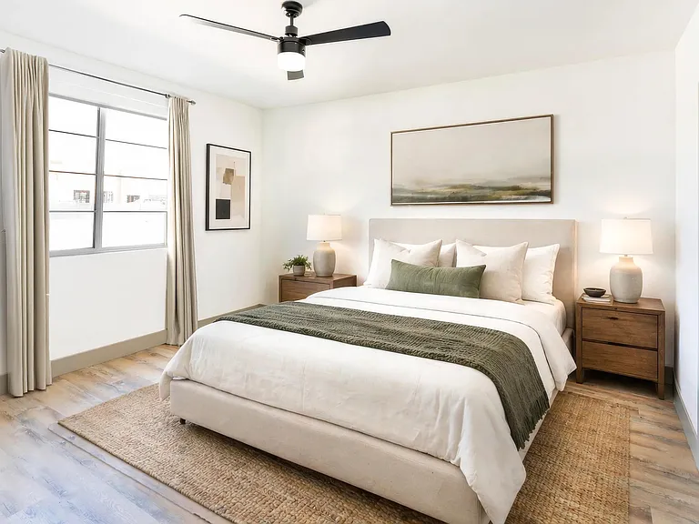 A spacious primary bedroom with wood-style flooring, ceiling fan, and generous natural light for a comfortable, everyday retreat.