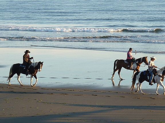 Horseback riding on beach.