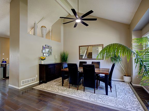 Large dining room with high ceilings that connects to kitchen and upstairs