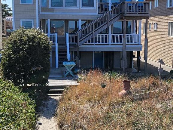 View from Bay dune with elevator addition (elevator stops at all floors). First floor garages, 2nd floor rental unit with large open porch, 3rd floor owner.
