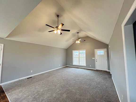Living area with two ceiling fans in a vaulted ceiling