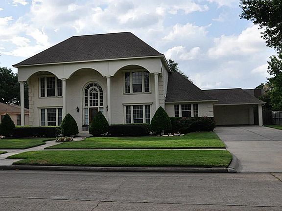 Double-wide driveway Porte-cochere with ceiling fans. Four-car tandem garage, currently partially us