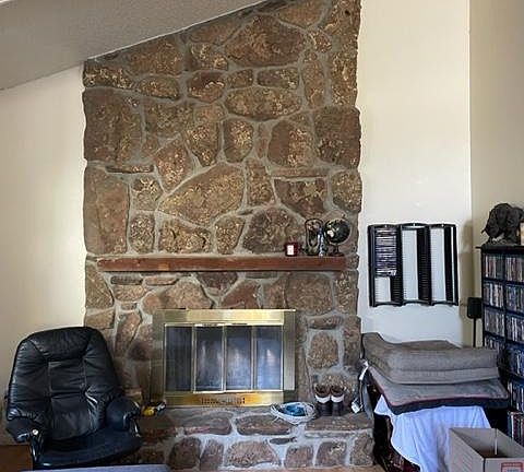 LR with beautiful stone mantel to the vaulted ceiling