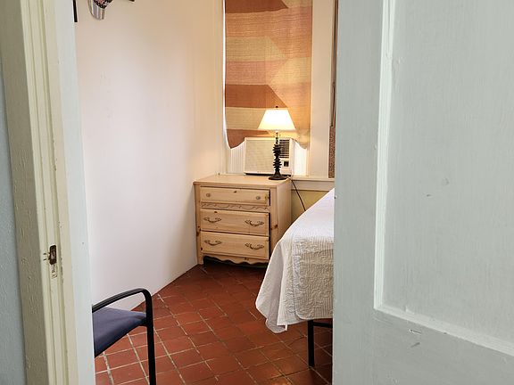 Cozy room. Front yard view with 4 windows. Twin bed, tile floor, window AC/Heat unit, work station and TV