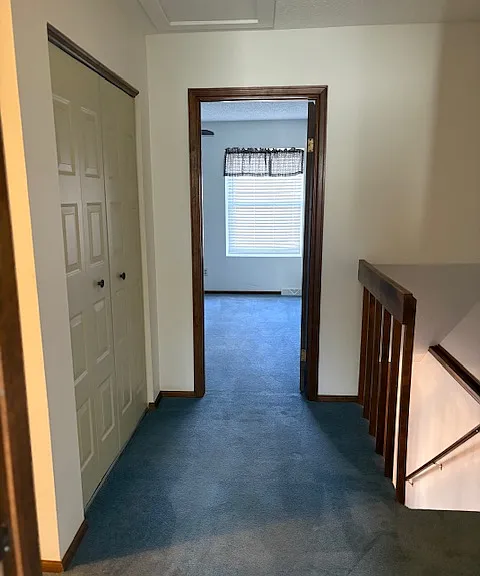 upstairs hallway with linen closet looking into 2nd bedroom