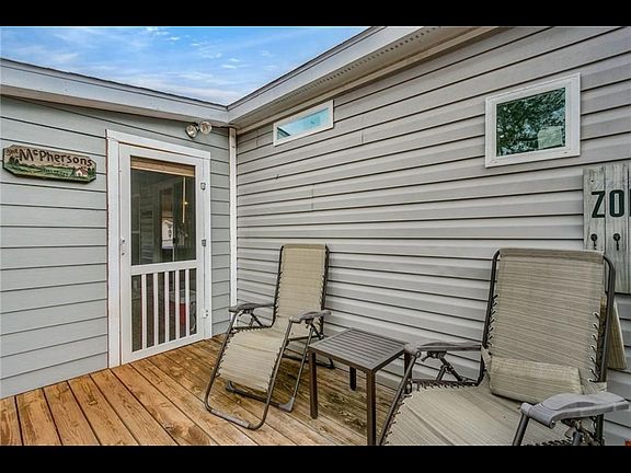 Small deck connected to the fenced in back yard.