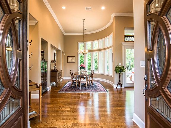 Walk through the gorgeous double doors and into a light and spacious entry that opens into the formal dining area. The large cur