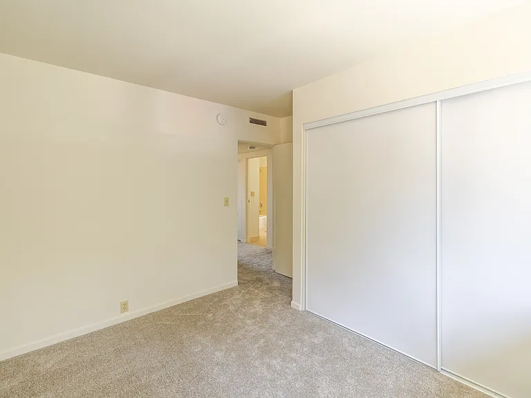 Bedroom A with generous closet space and soft natural light.
