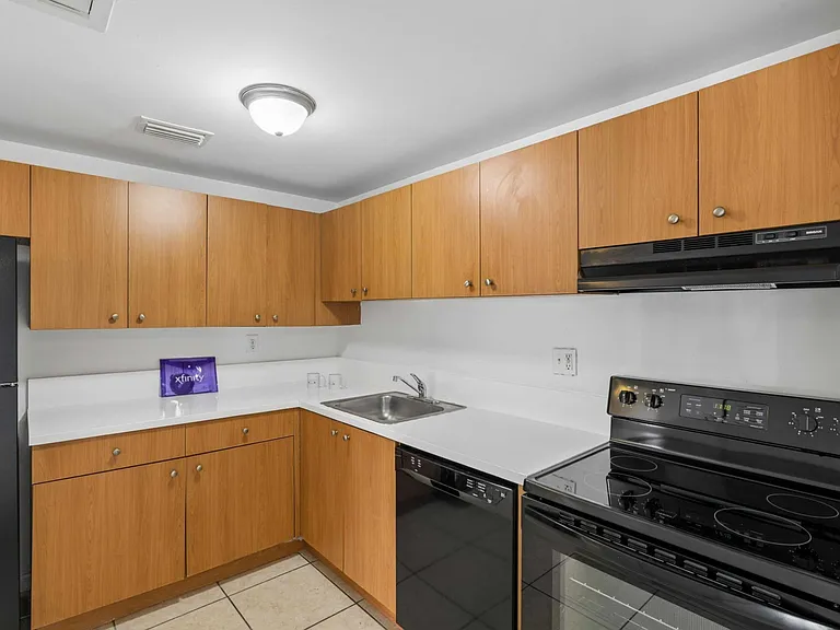 Elevate your lifestyle at Clear Lake Palms Apartments with this modern kitchen featuring sleek appliances and ample cabinetry. Perfect for culinary creations, this space combines functionality and style. Schedule your tour today!