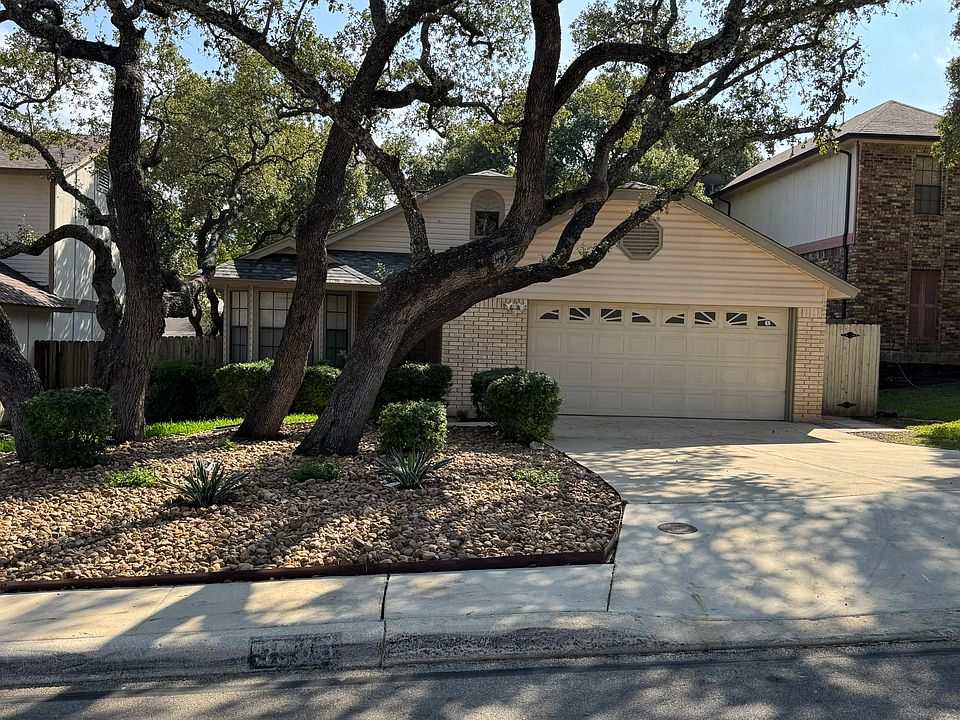 Redesigned front yard with drought tolerant floral plants surround by beautiful oak trees, fresh grown grass and river rock. Easy care