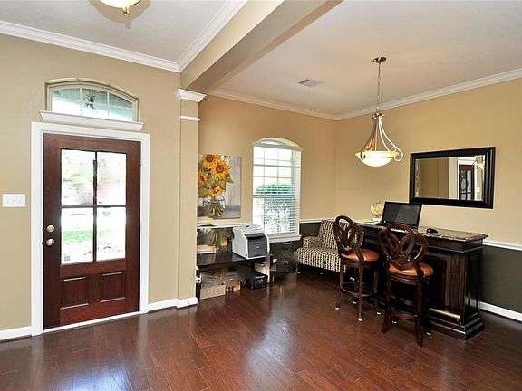 Beautiful Formal dining room with wood floors, chair rail, two tone paint and upgraded chandelier. Formal dining room (currently being used as work space) also has access to kitchen area.