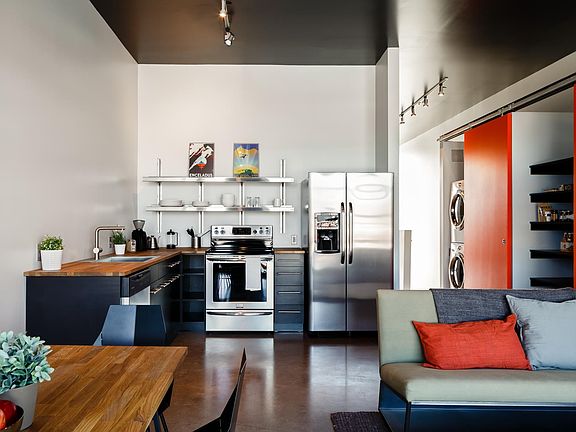 2-bedroom kitchen with butcher block countertops, induction stove, soft close drawers and stainless appliances. There's a pantry, closet and washer/dryer in hallway.