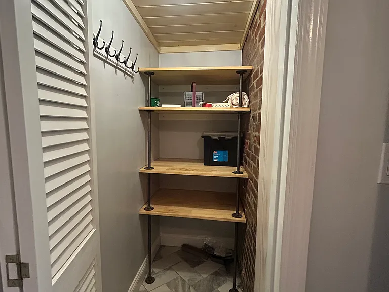 closet in 1st floor 1/2 bath with built in shelving and hanging