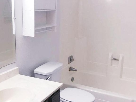 Clean, bright full bath with tiled floors, tub/shower, vanity with lots of storage space and fan!
