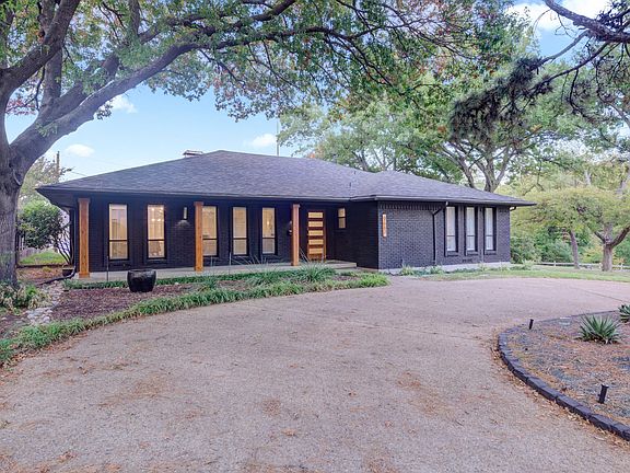 Front exterior of home with a circle drive and 2 car garage around the back