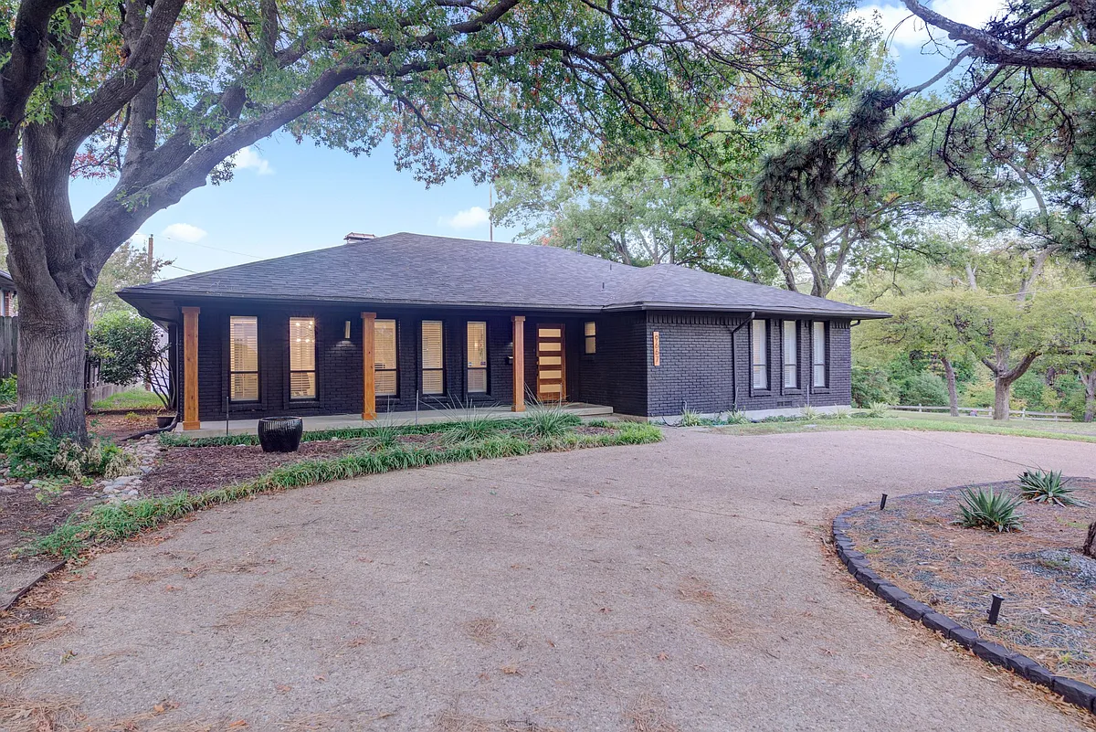 Front exterior of home with a circle drive and 2 car garage around the back - 9667 Timberleaf Dr