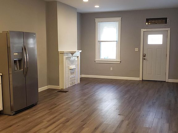 Front room, open plan to kitchen, looking at front door.