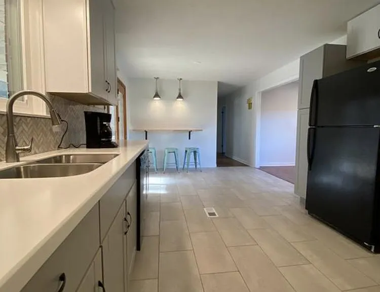 Stunning modern kitchen with white upper and grey lower cabinets and white quartz countertops