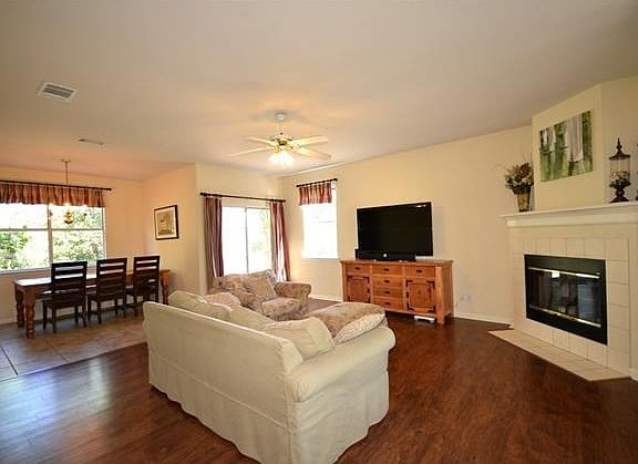 This family room boasts laminate floors, plenty of space, a cozy fireplace, abundant light, and is o