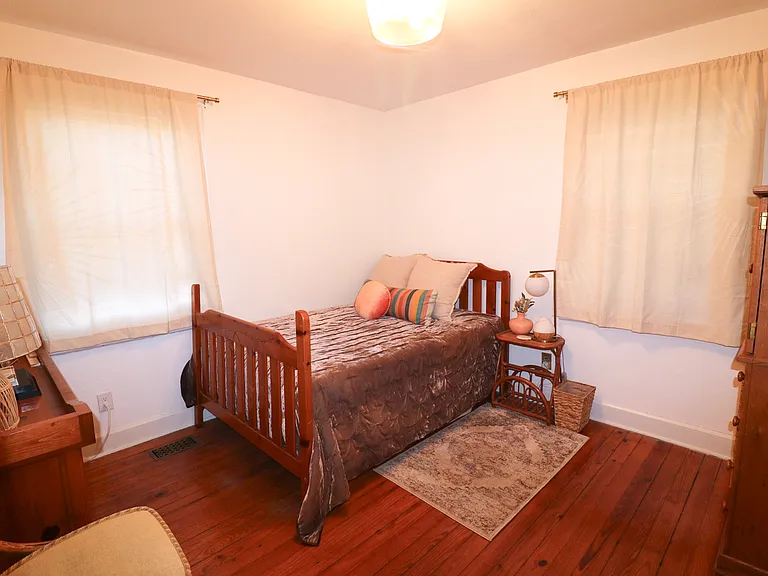 Secondary bedroom has original hardwood floors, a full bed with comfortable mattress and bedding.