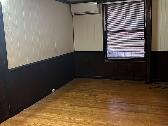 Living Room (hardwood floor). Interior entrance to apt is by door on the left. Ductless mini-split is on top of front wall. 2nd HVAC unit is in the rear of apartment. Room is 21 ft x 10.5 ft