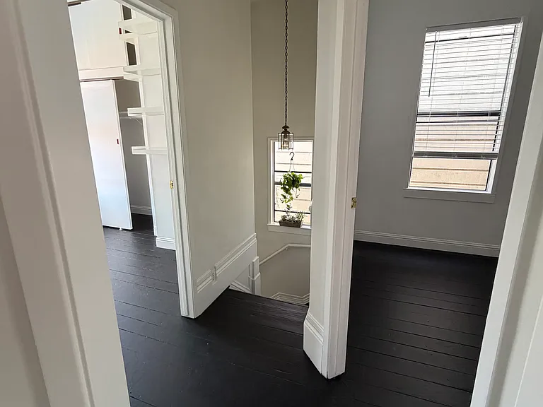 View from the dining room toward the staircase, highlighting the home's layout, with the bonus room featuring built-in shelves to the left and Bedroom 1 to the right.