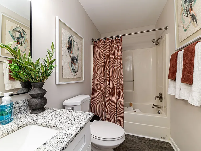 Bright bathroom with granite counters and bathtub