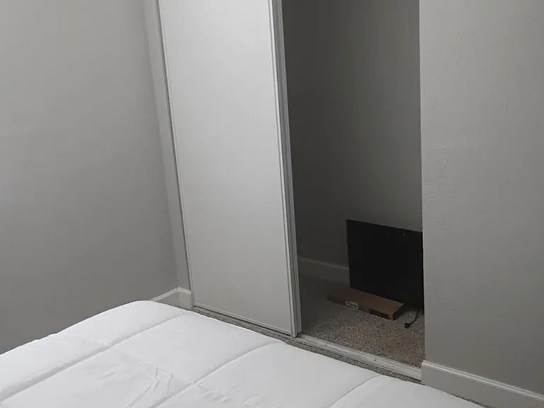 Bedroom with a sliding-door closet offering convenient hanging storage and easy access to everyday essentials.