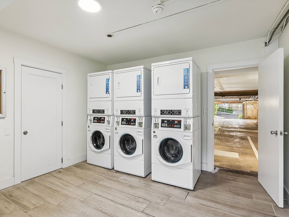 Laundry room with washing machines neatly arranged on a wooden floor