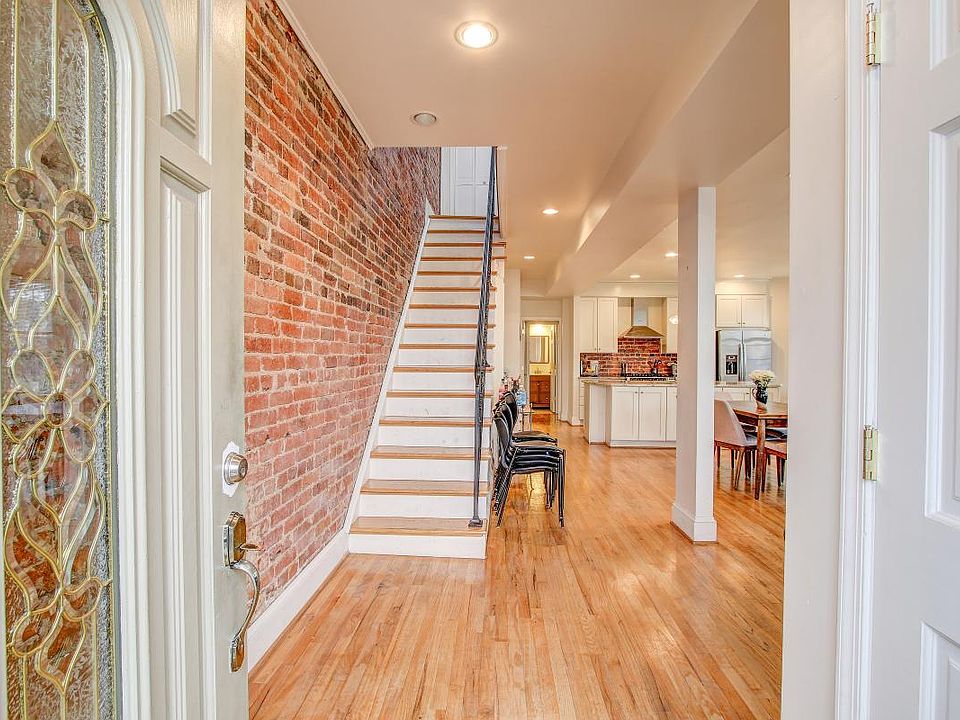 Entrance way featuring exposed brick and open concept through out first floor.