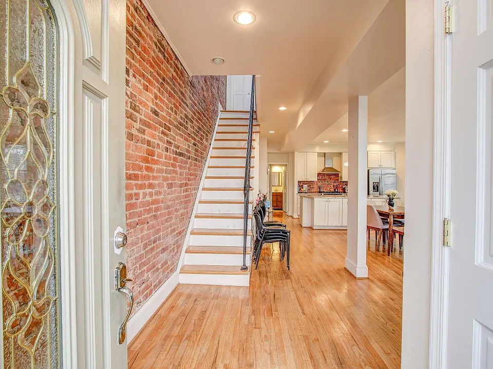 Entrance way featuring exposed brick and open concept through out first floor.