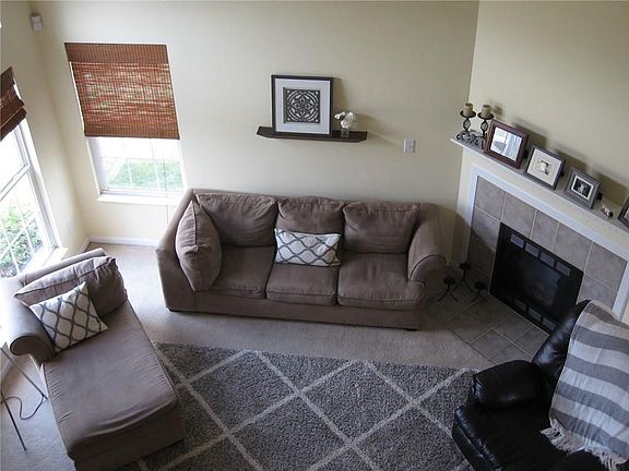 View of Great Room from the Staircase with Ceramic Fireplace and Cathedral Ceiling.