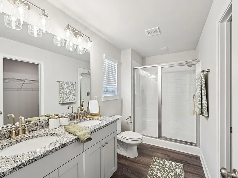 Primary bathroom featuring a double vanity and walk-in shower.
