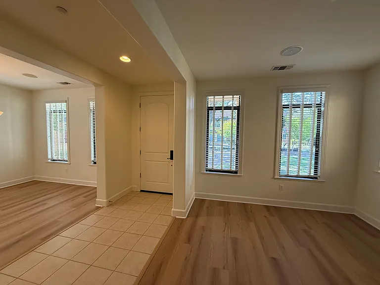 Bright, airy living room and dining room feature large windows, vinyl flooring throughout.