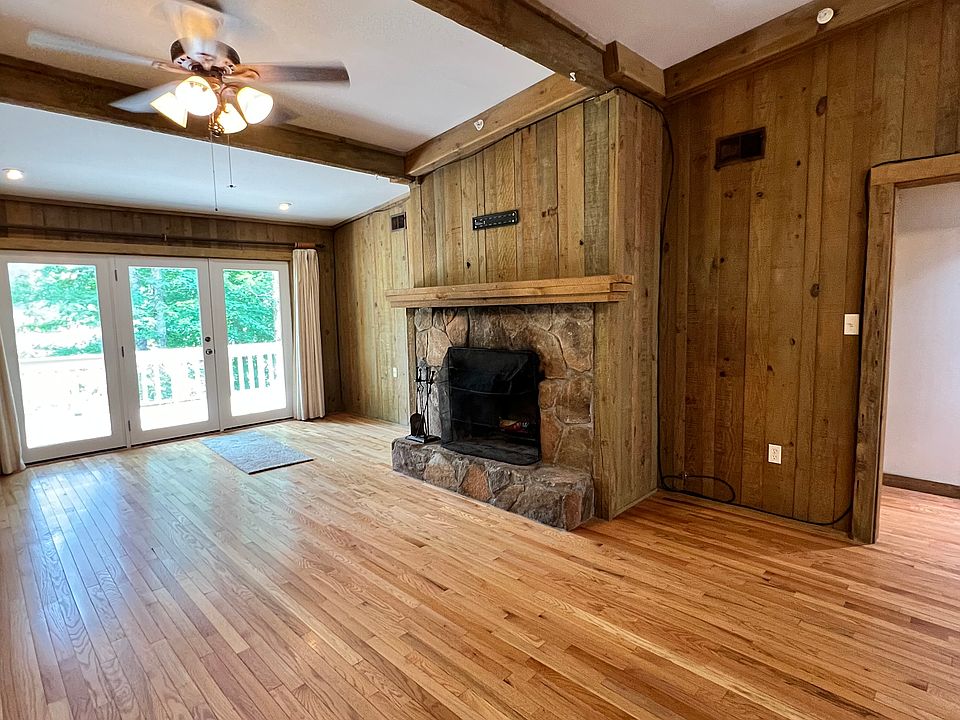 Large open dining/living room with direct deck access and wood-burning fireplace