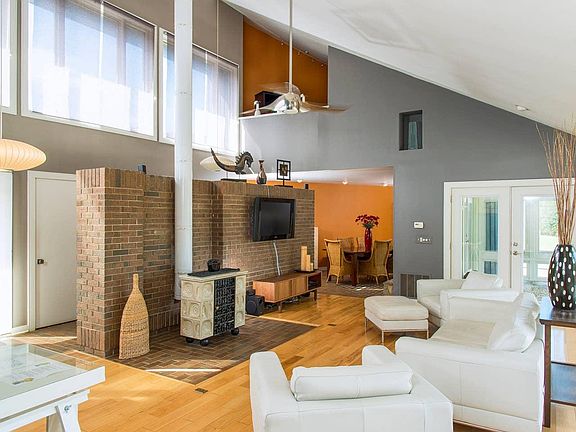 Living Room with Plasma TV, Sunroom to the Right, One of two Lofts above the High-Tech Fan