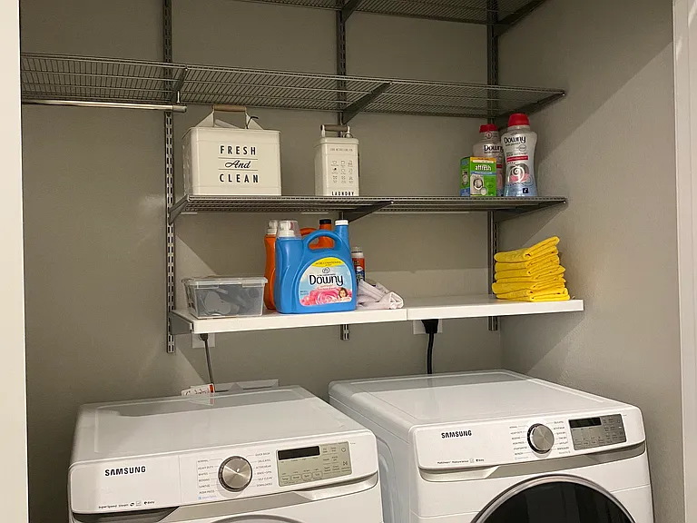 Laundry area with double doors and storage