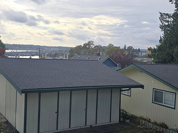 View of water, storage unit and back of house